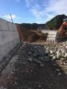 Vallon Pont D'Arc - Début du parement en pierres sur blocs en béton préfabriqué après scellement d'encrage métallique